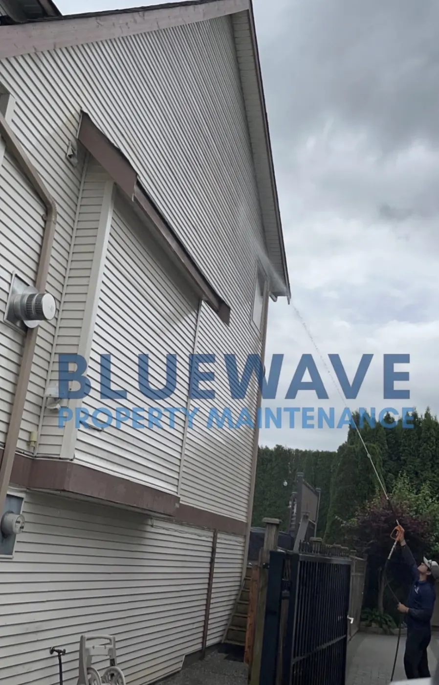 BlueWave technician cleaning an exterior awning overhang
